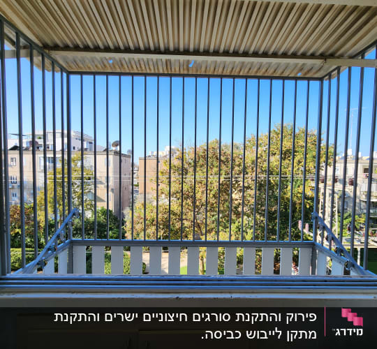 סורגים מתכתיים על מרפסת עם נוף לעצים